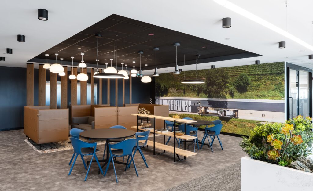 A wide-format photographic wall mural titled "Building Greatness" installed in a corporate lounge area to enhance workplace culture.